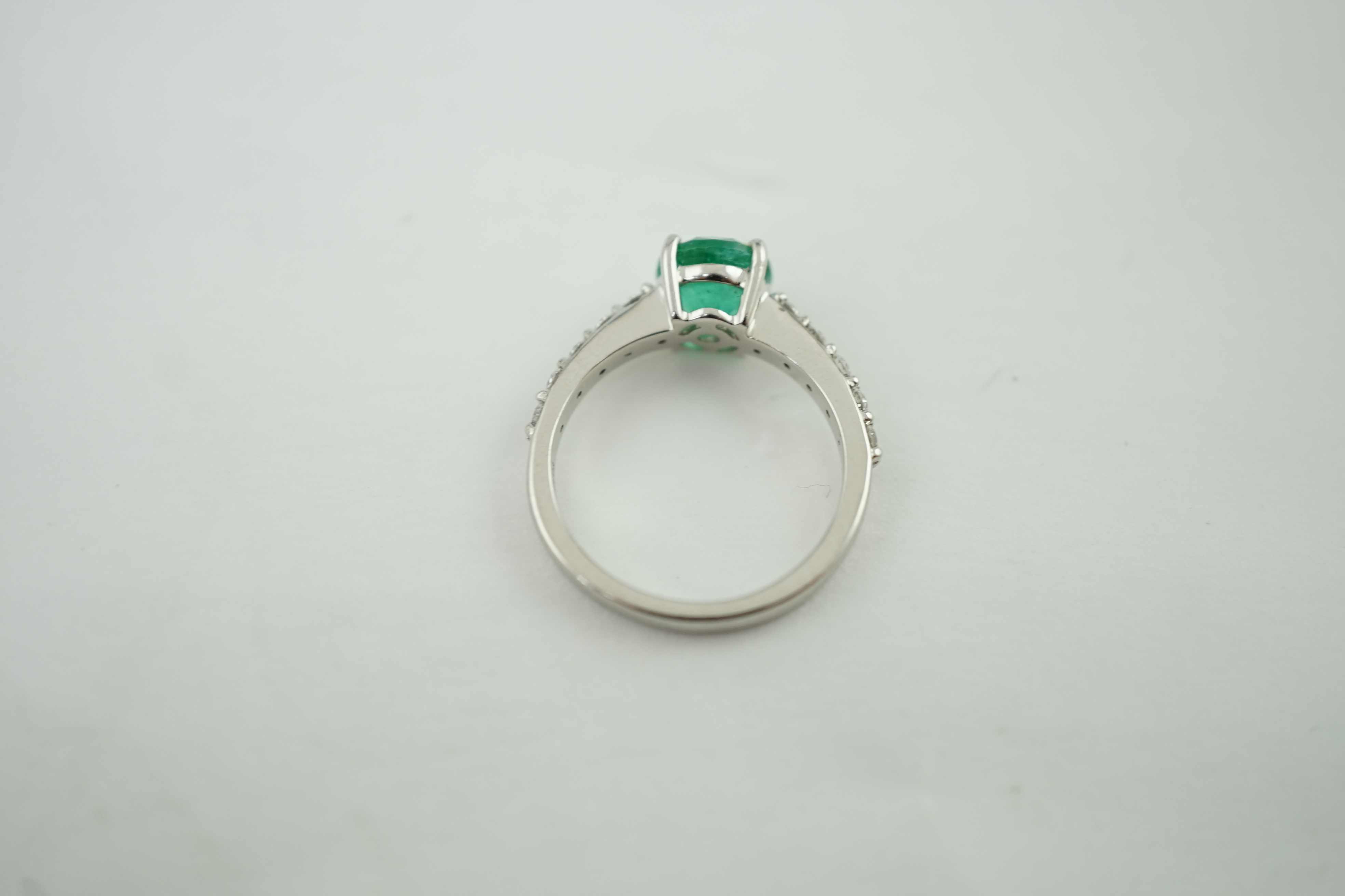 A modern Rhapsody platinum and single stone round cut emerald set ring